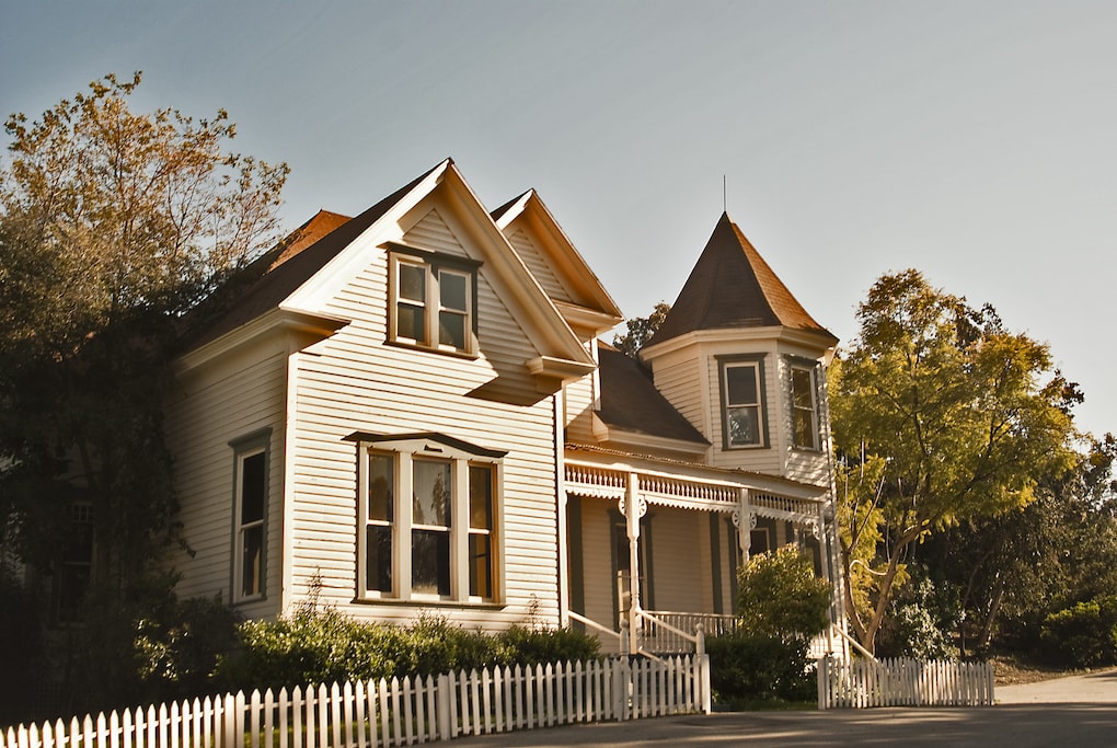 victorian style antique home with white fence
