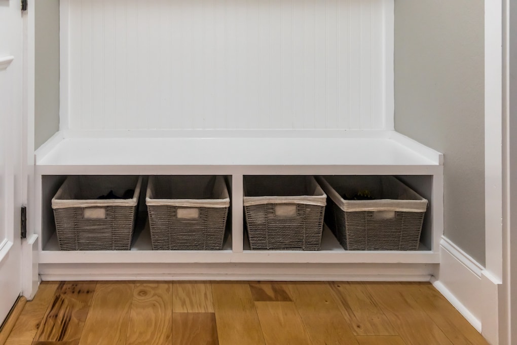 a row shelf of storage baskets for home organization inside the mudroom