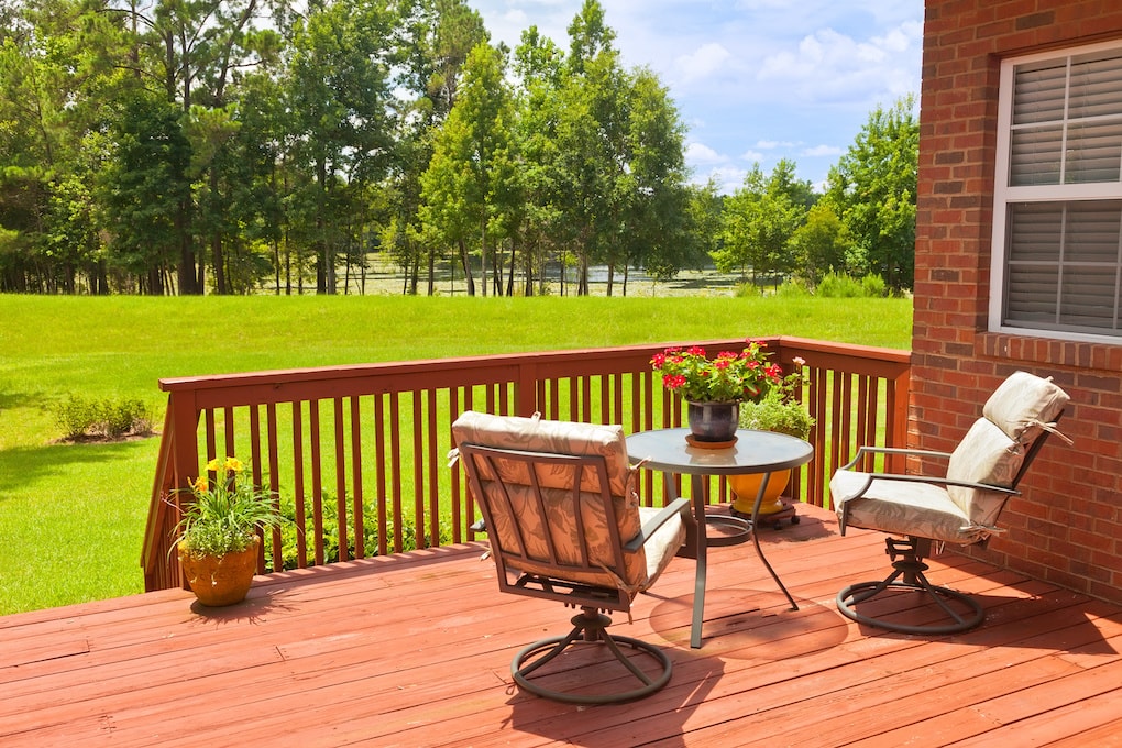 cedar decking materials with chairs and green grass backyard