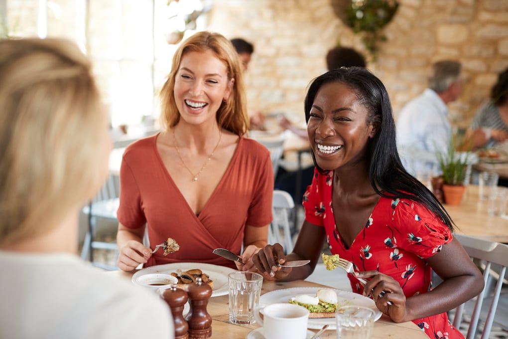 Young female friends smiling at brunch in one of the restaurants in sudbury